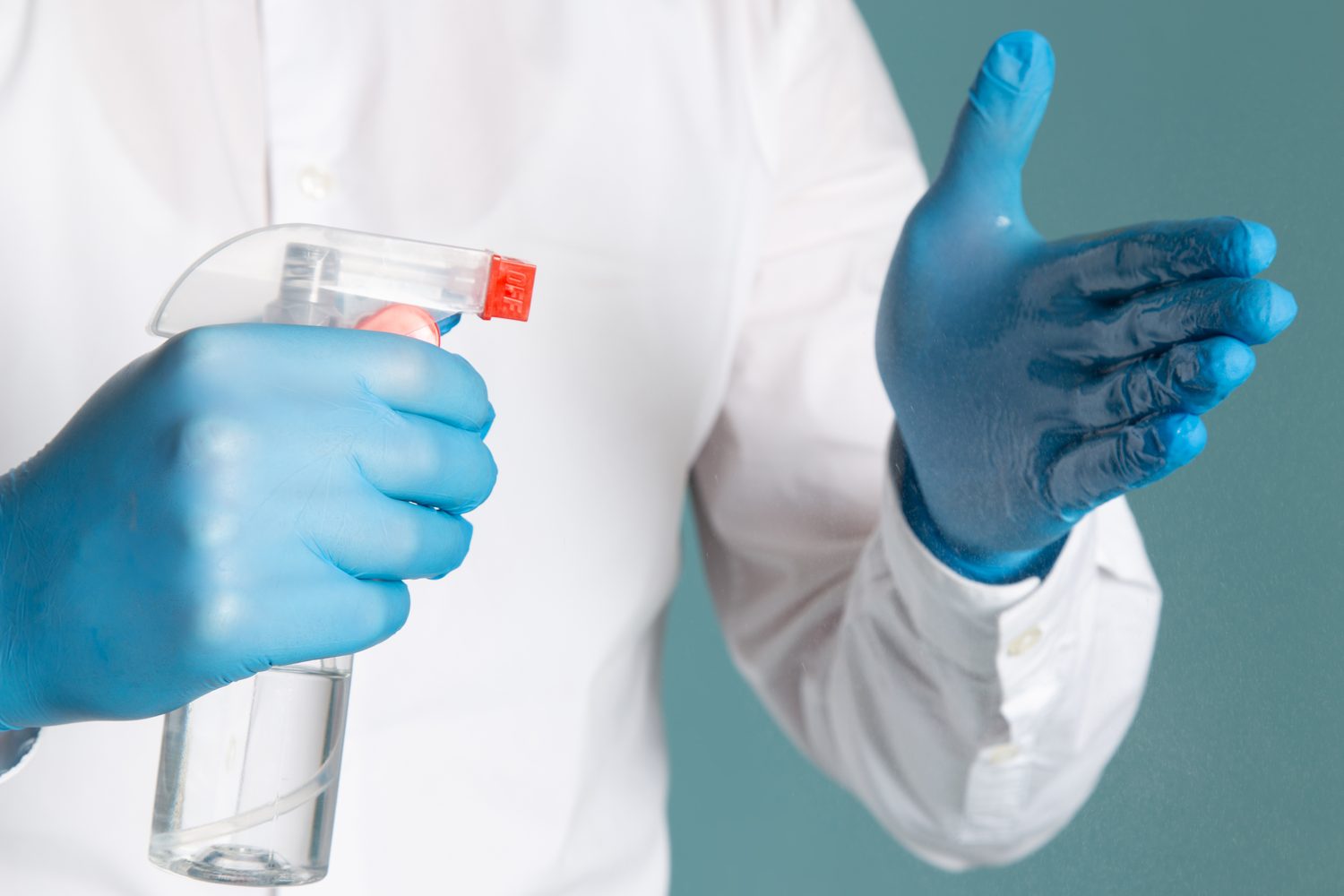 Bio cleaning with full protective equipment Specialist cleaner in protective gloves with disinfectant spray